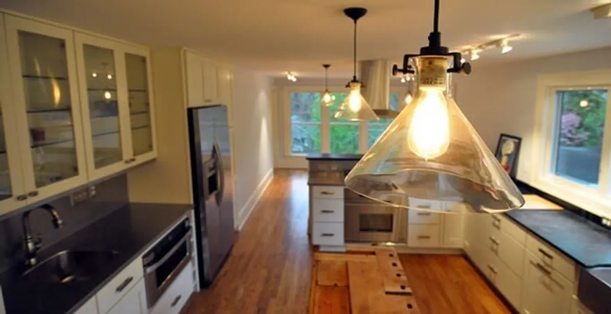 Residential electrician installing modern indoor light fixture in a home in Glendale, AZ